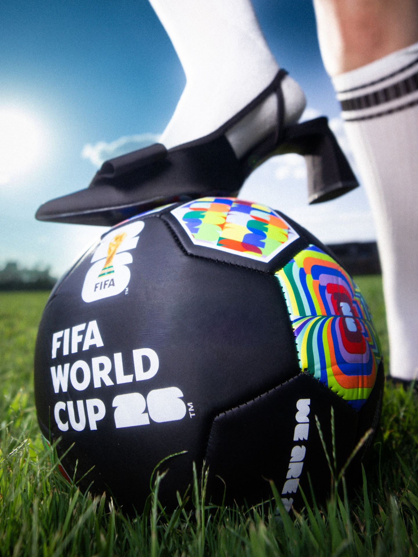 High-heeled foot resting on a World Cup soccer ball in grass